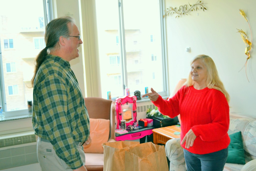 Founder John Visnauskas and a woman receiving food engage in a jolly conversation.