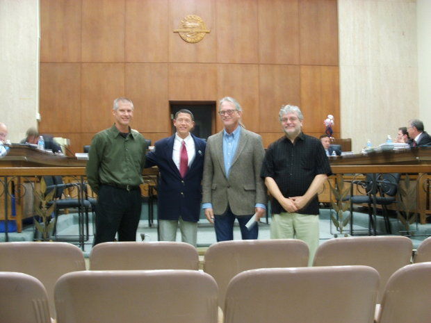 Four men stand and pose at the front of Parma City Hall chambers.